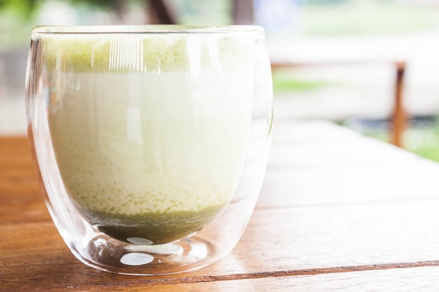 Glass of hot matcha green tea latte at coffee shop