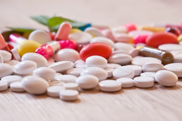 Pills and capsules on the wooden background