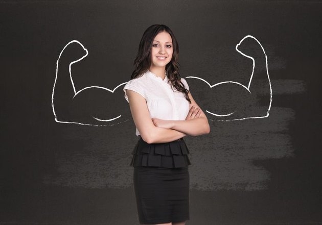 Business woman with drawn powerful hands. Black chalkboard background.