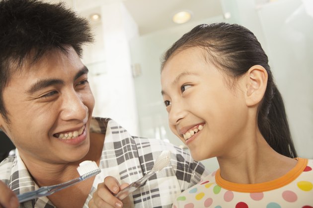 Father and Daughter Brushing Teeth Together
