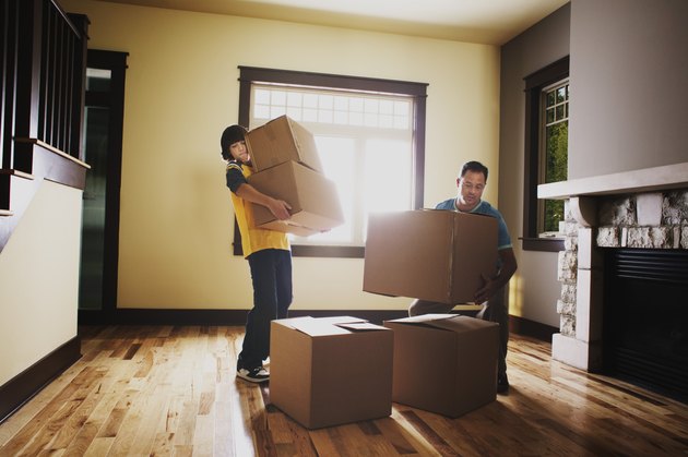 Father and son stacking boxes in house