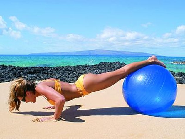 Photo, woman wearing a swimsuit working out with a large blue ball on the beach, Color, High res