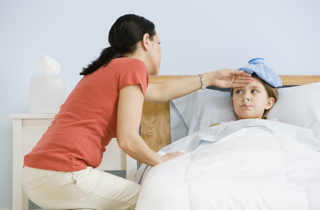 Hispanic mother checking daughter's temperature