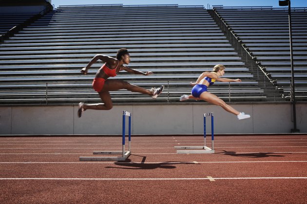Women jumping over hurdles