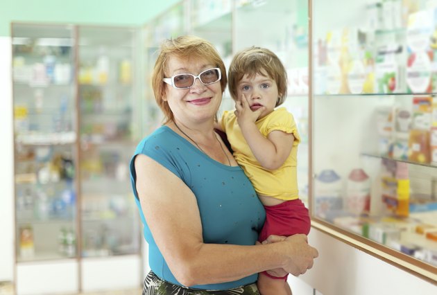 woman with child chooses drugs at pharmacy
