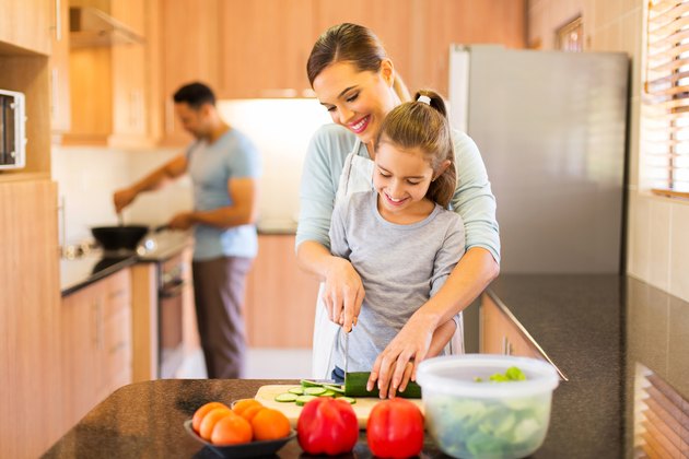 young family preparing meal in kitchen