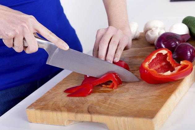 female hands chopping vegetables on a wooden board