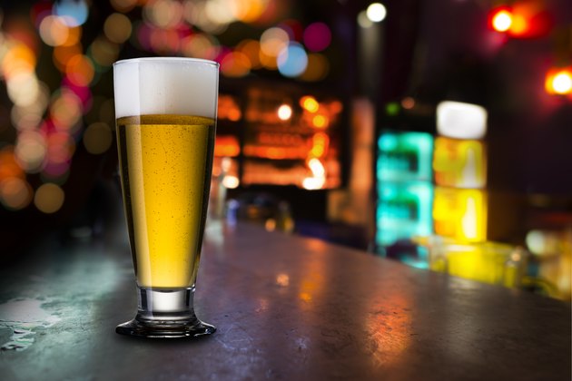 Glass of cold beer with bar scene