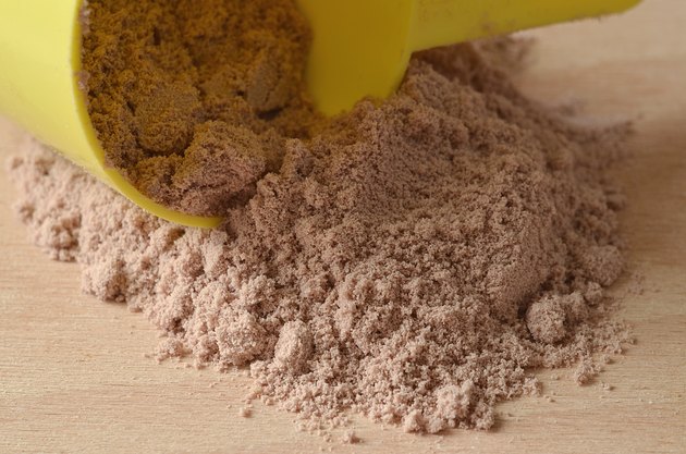 Chocolate protein powder spilled from yellow scoop