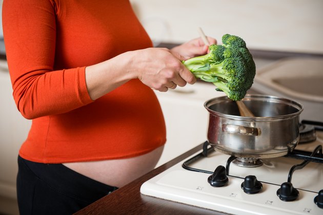 Pregnant woman cooking broccoli