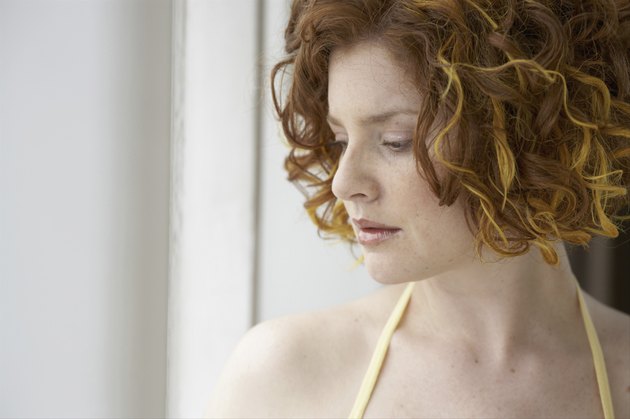 Young woman looking trough window