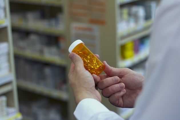 Pharmacist examines a bottle of vitamins