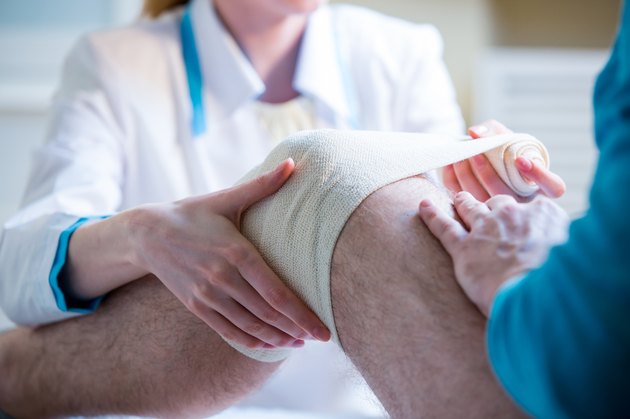 Nurse rewinding knee bandage