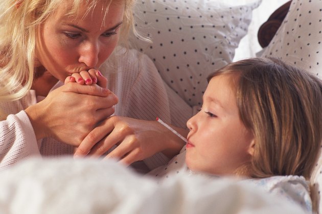 Mother kissing sick daughter's hand