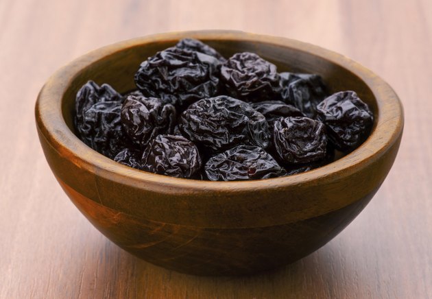 lot of prunes in transparent glass bowl