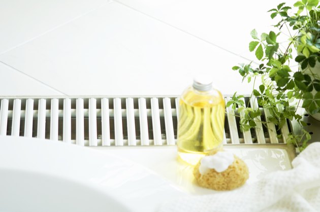 Bath oil and a bath sponge next to hot tub