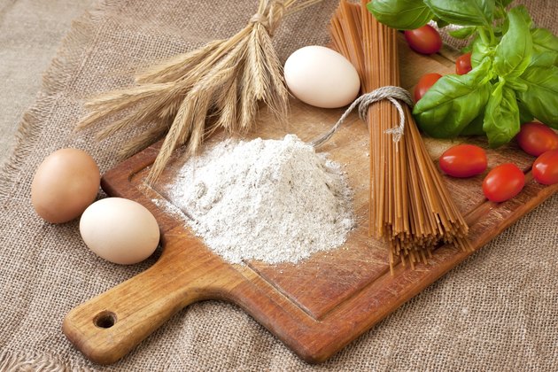 Raw pasta and ingredients on the wooden board