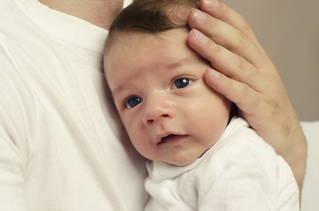Father's hands holding his newborn with love,