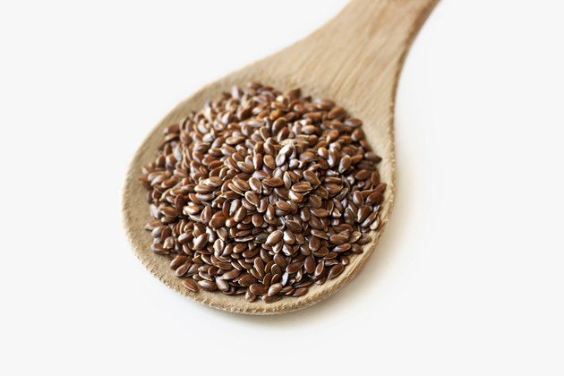 Spoonful of flax seeds isolated on white