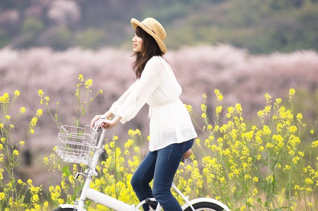 Woman cycling through spring landscape