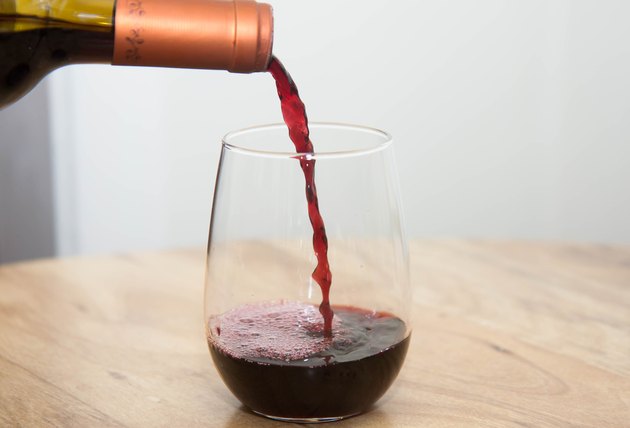 Pouring red wine into a stemless glass
