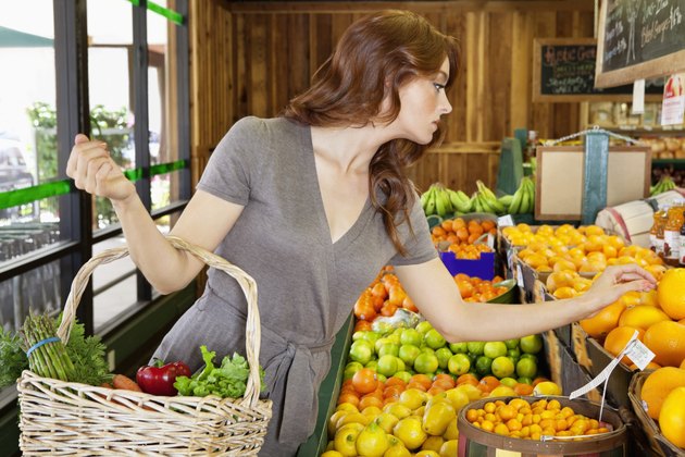 Beautiful young female shopping for fruits in market