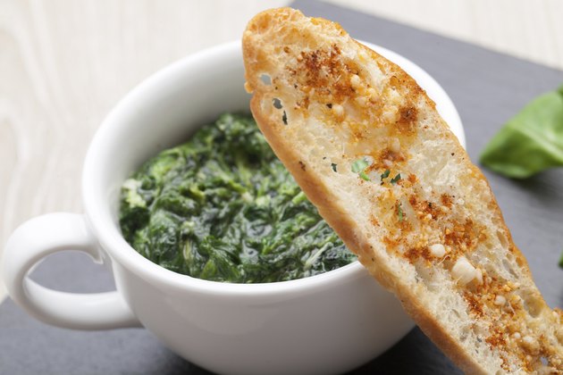 Sauteed garlic spinach dish, baked bread slice with melted cheese