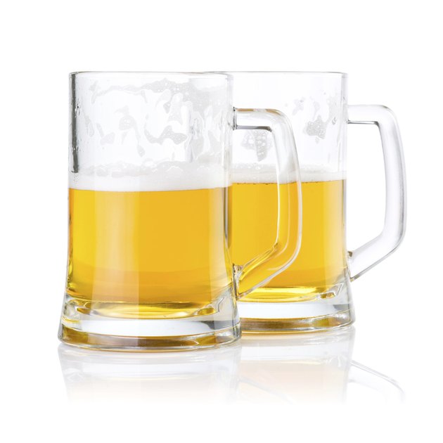 Two half glasses of fresh beer with foam isolated