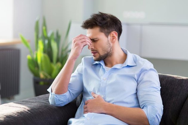 Man On Sofa Having Headache