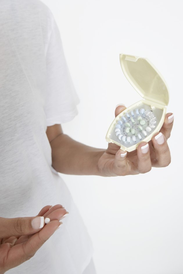 Woman holding pills, close-up