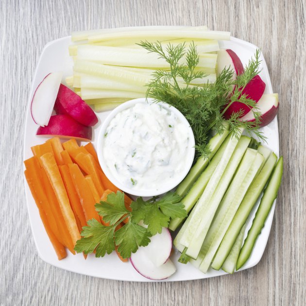vegetable assortment and sauce with feta cheese on wooden background