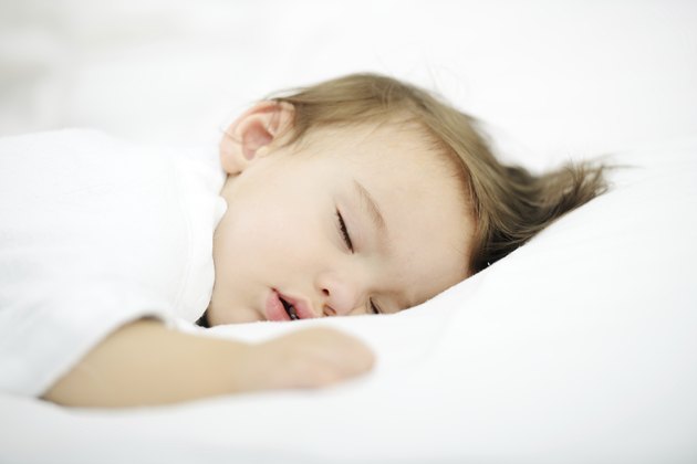 Baby sleeping on white bed