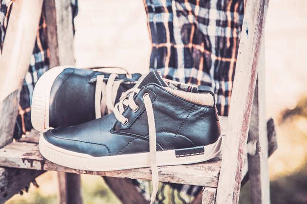 Men's shoes, wrapped in a scarf on a wooden ladder