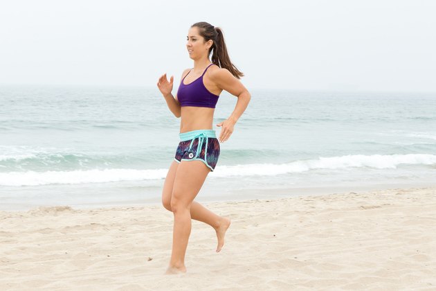 女人倒退在她的海​​滩锻炼