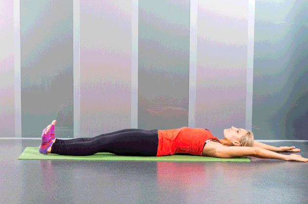 Woman performing roll up Pilates ab exercise.