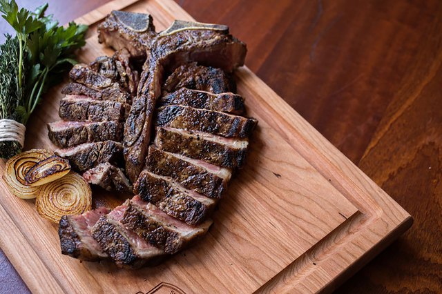 T bone steak on wood board
