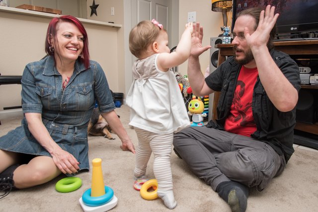 Alanna smiles at her husband and daughter