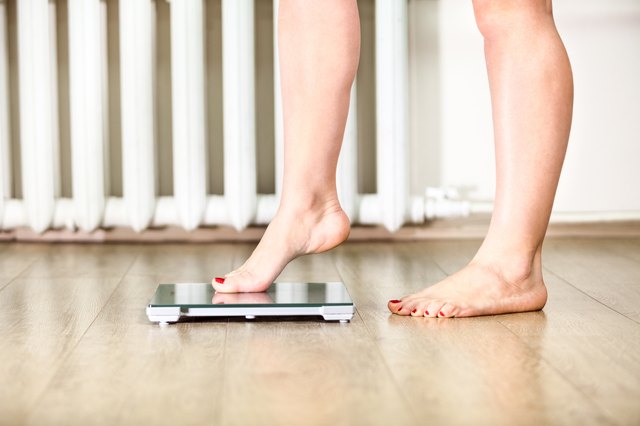 woman standing on bathroom scale to check her weight