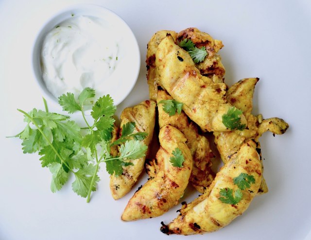 Turmeric-Marinated Grilled Chicken Tenders on a marble tabletop