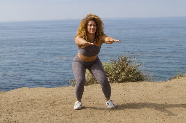Daisha Graf doing squat pulses on the beach