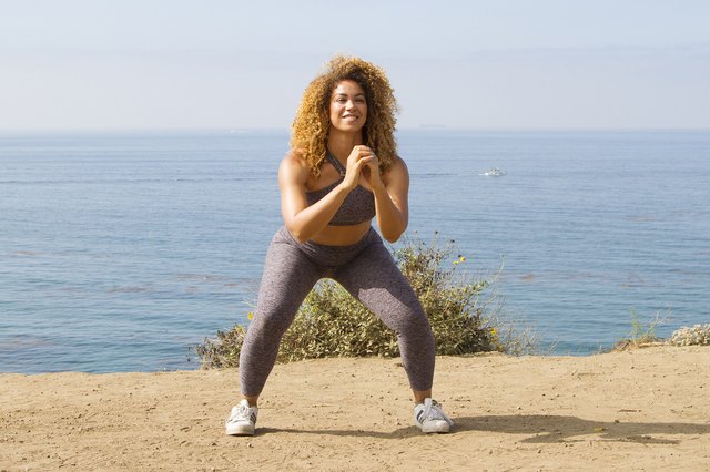 Daisha Graf doing squat jacks on the beach