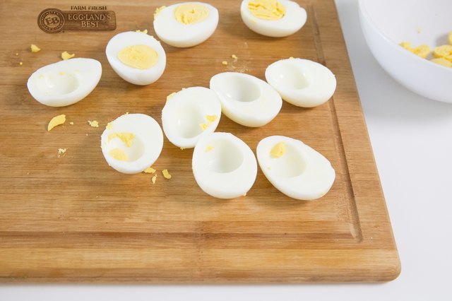 scooping out yolk from hard-boiled eggs