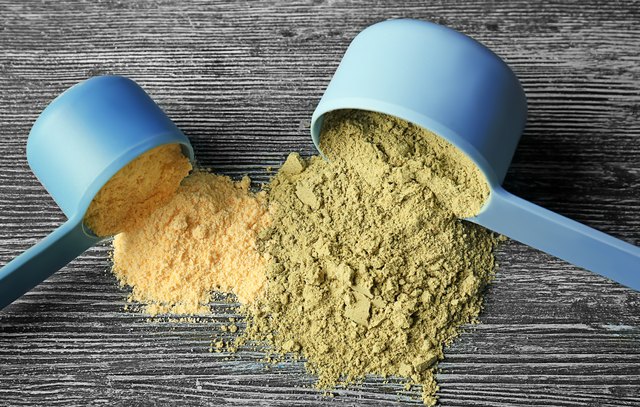 Scoops with hemp protein powder on wooden table