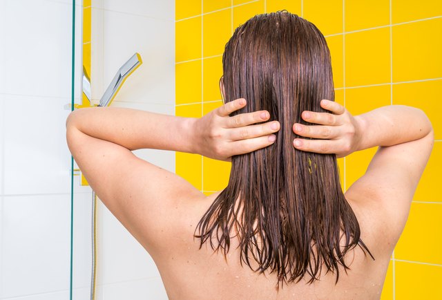 Attractive woman applying olive oil on her hair