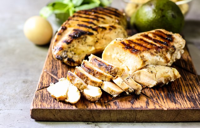 grilled chicken fillets on wooden cutting board