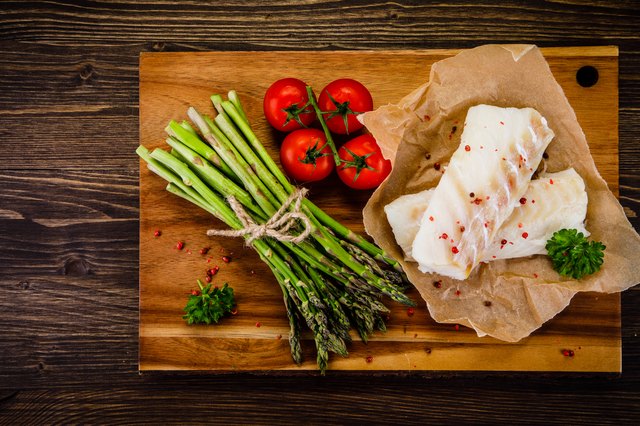 Fresh raw cod fillets on cutting board