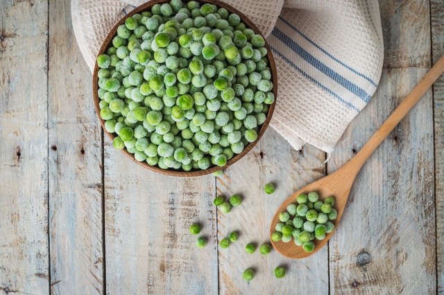 Frozen peas on a wooden table