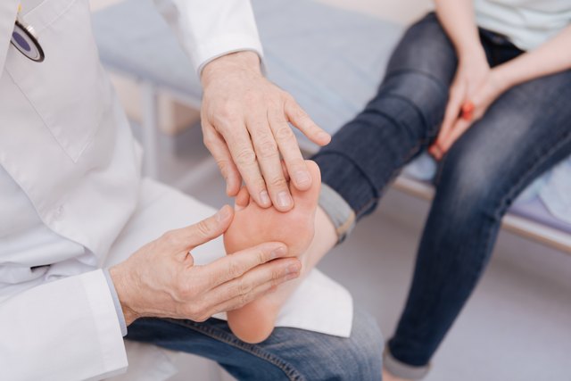 Delicate focused rheumatologist conducting special checkup
