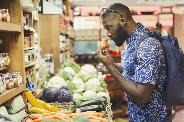 Man shopping, smelling spices in grocery store