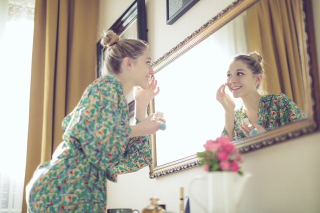 Young woman applying aloe vera gel to her face